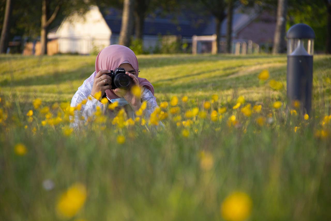 Woman taking a photo in the grass