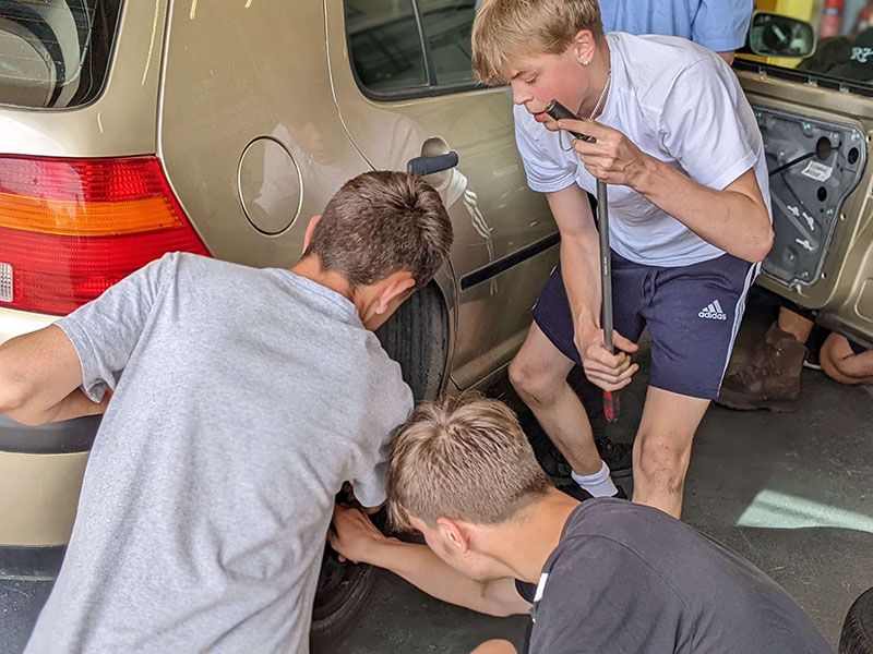 Students changing a tyre on a car