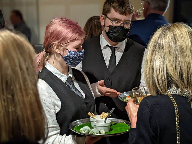 Students serving canapés in The Restaurant