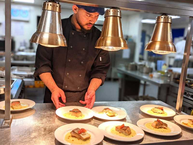 Student preparing plates of salmon